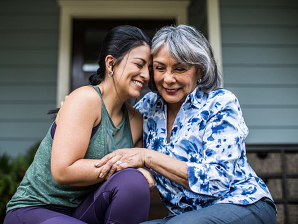 Two women embrace on a porch