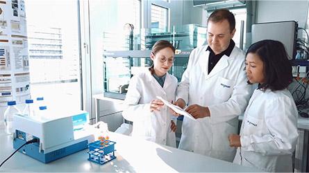 Three of MorphoSys’ scientists standing in the company’s labs in Planegg reviewing data  